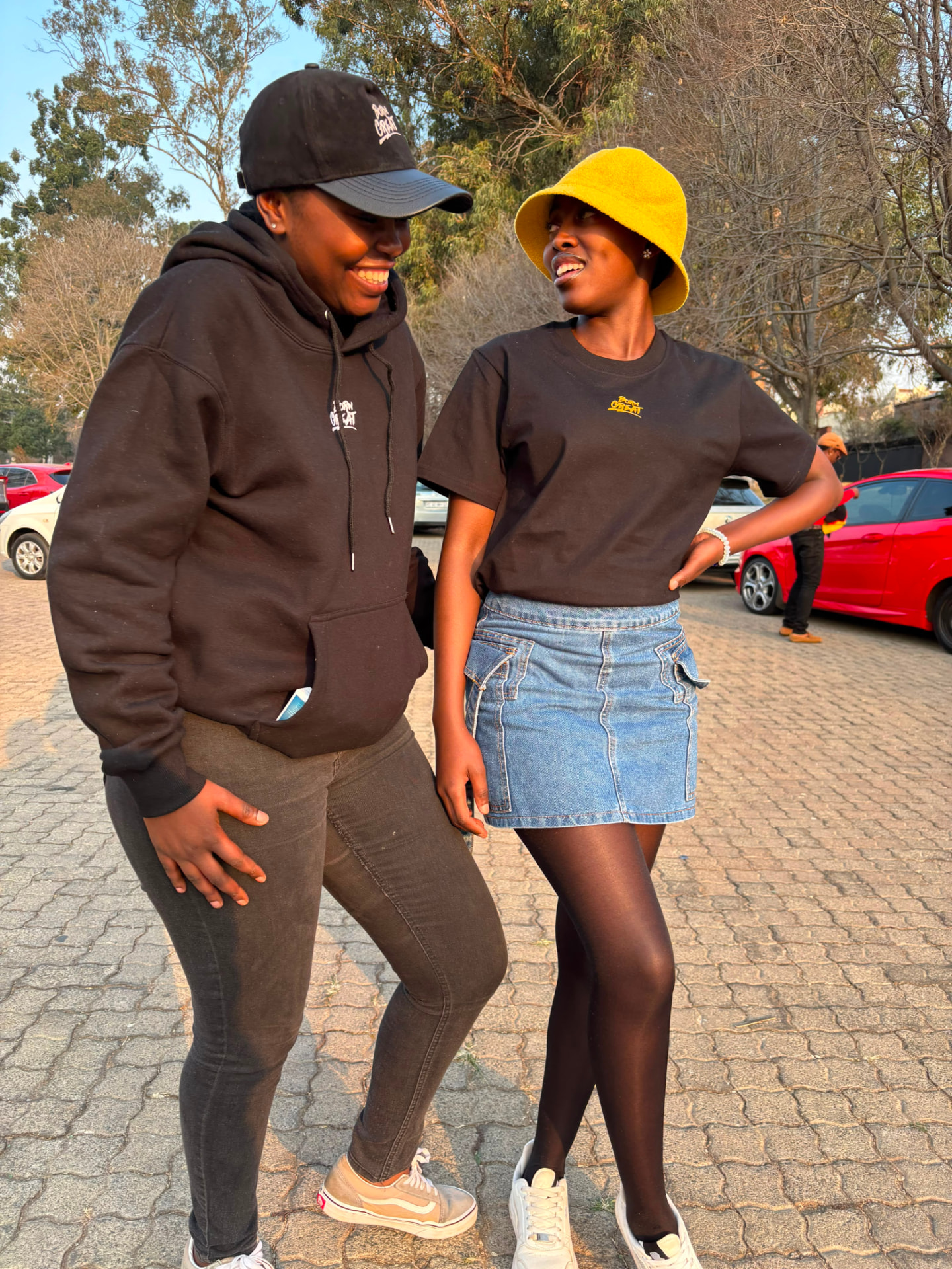 Two friends laughing in Born Great hoodie and tee, Johannesburg